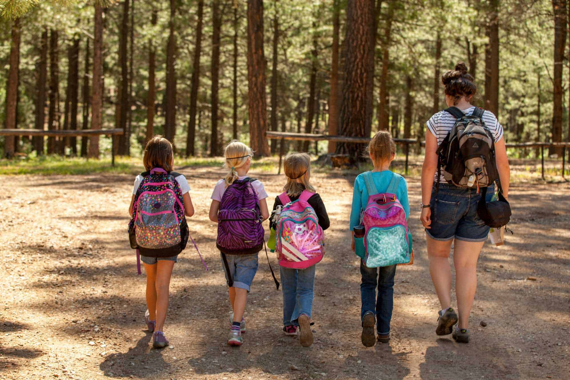 Girl scouts walking with troop leader